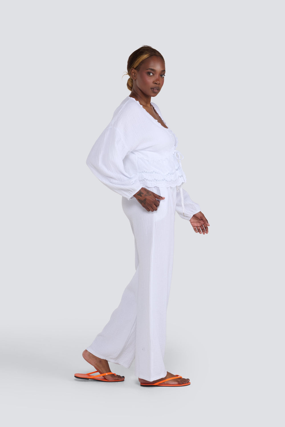 White textured long-sleeve top with lace trim and matching wide-leg pants.