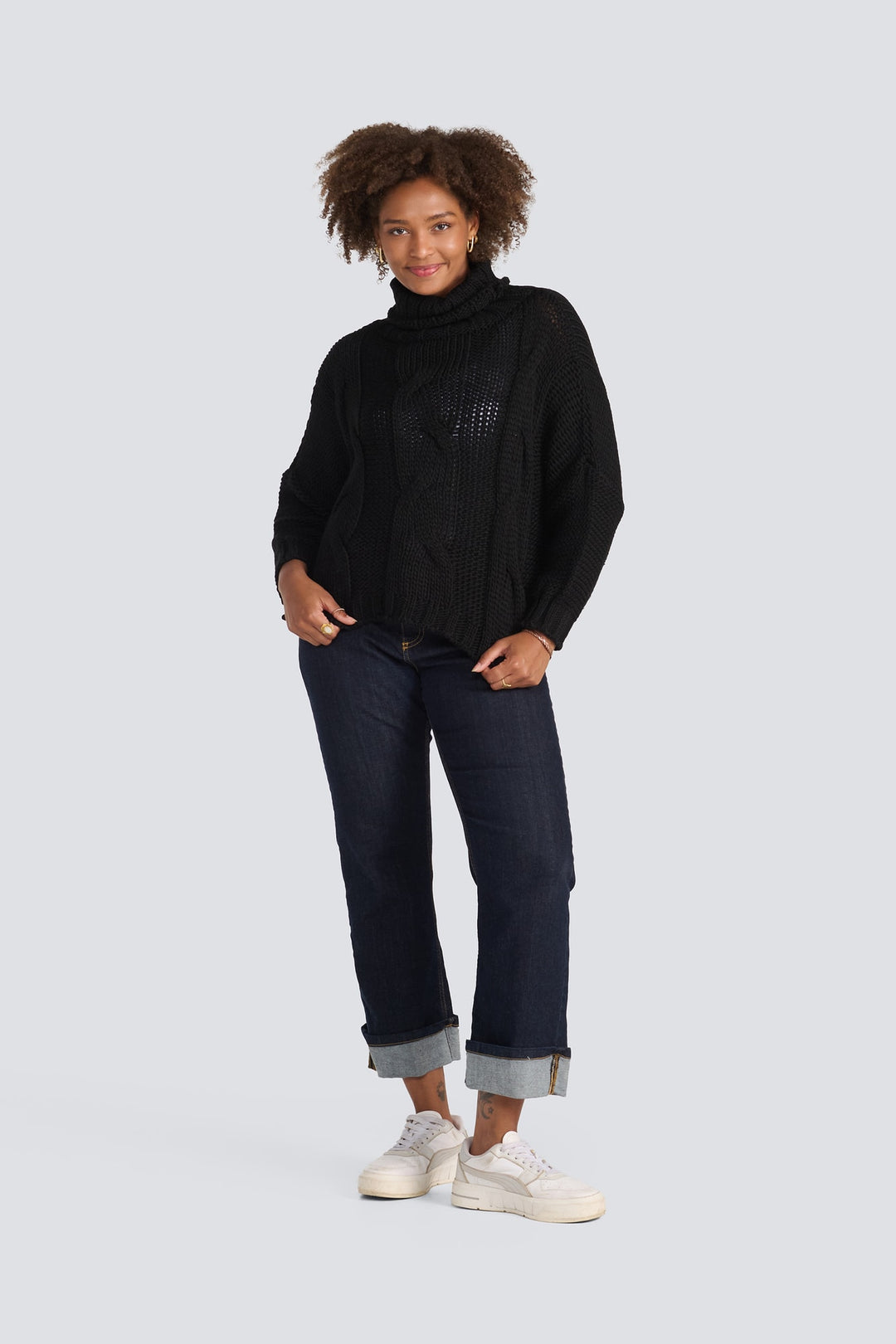Black chunky cable-knit turtleneck sweater with long sleeves and a relaxed fit.
