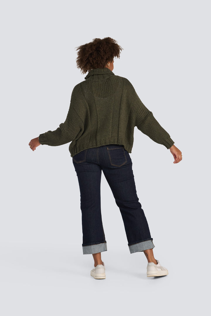 Olive green chunky knit turtleneck sweater with long sleeves and ribbed texture.