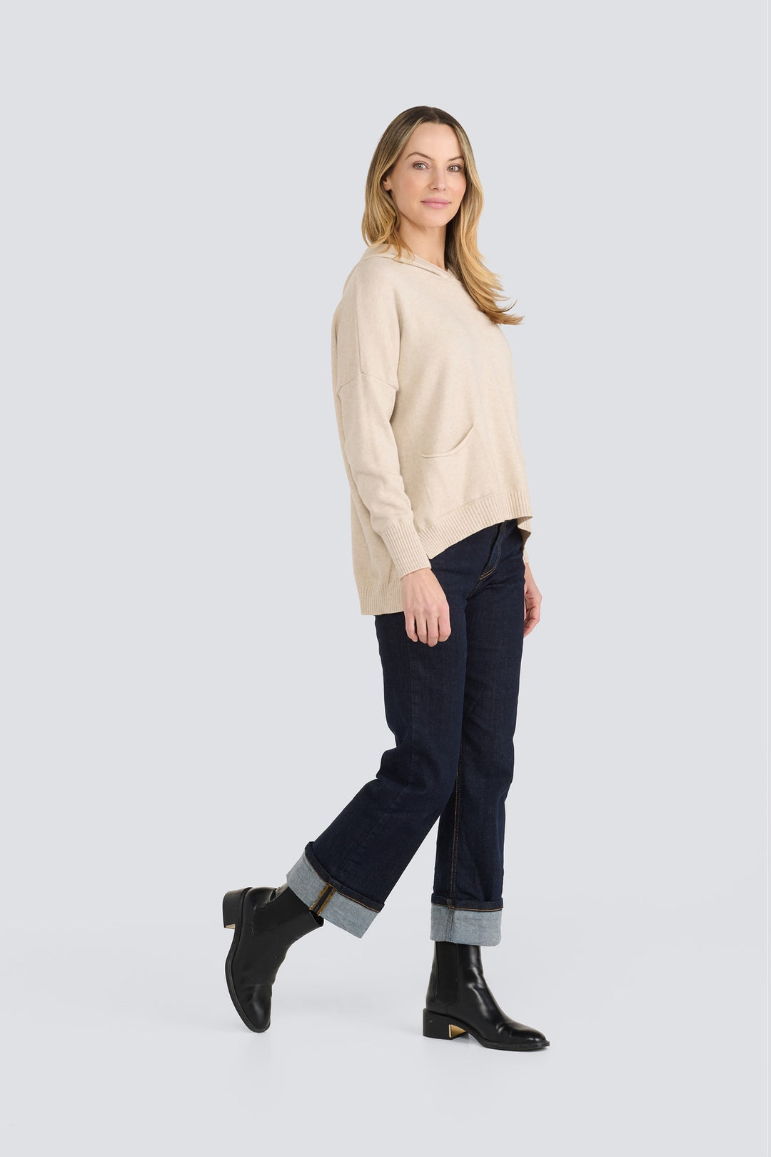 Beige knit hooded sweater with a front patch pocket and ribbed hem.