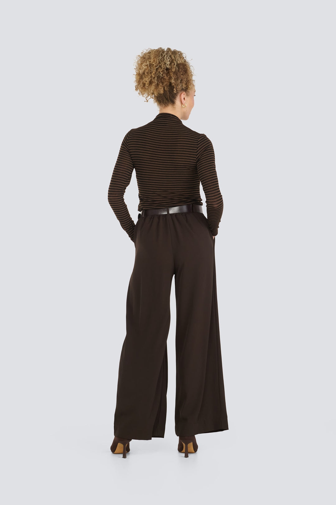 Brown striped long-sleeve top paired with dark brown wide-leg trousers.