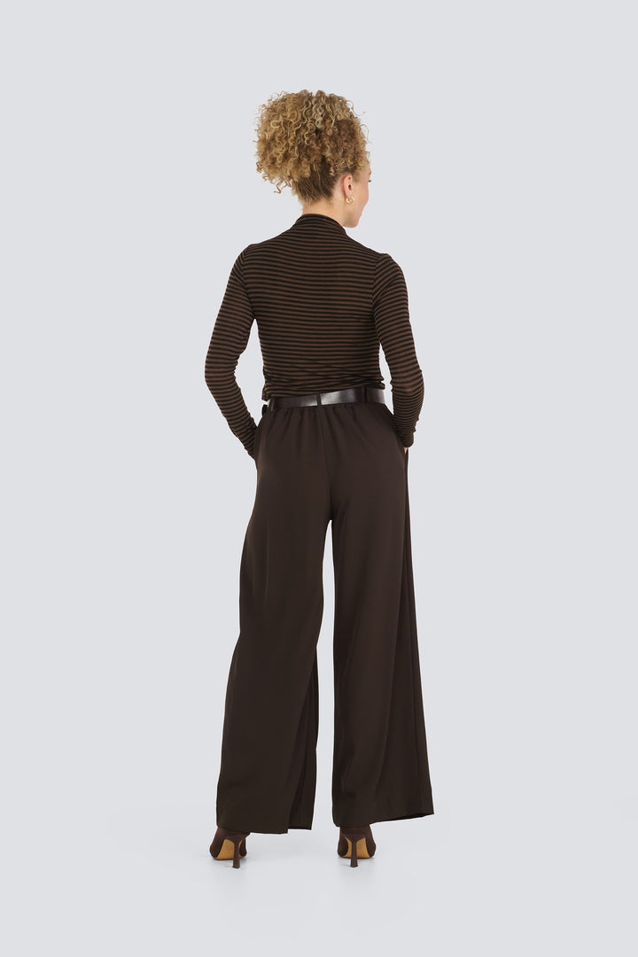 Brown striped long-sleeve top paired with dark brown wide-leg trousers.