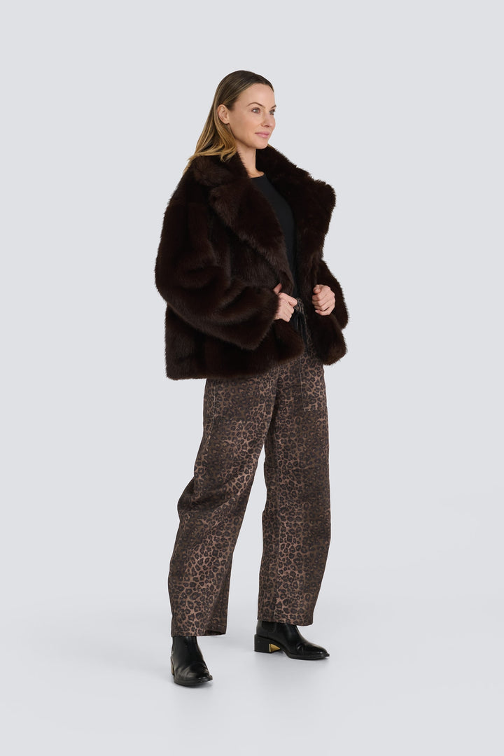 Dark brown faux fur jacket with wide lapels, styled with leopard print pants.
