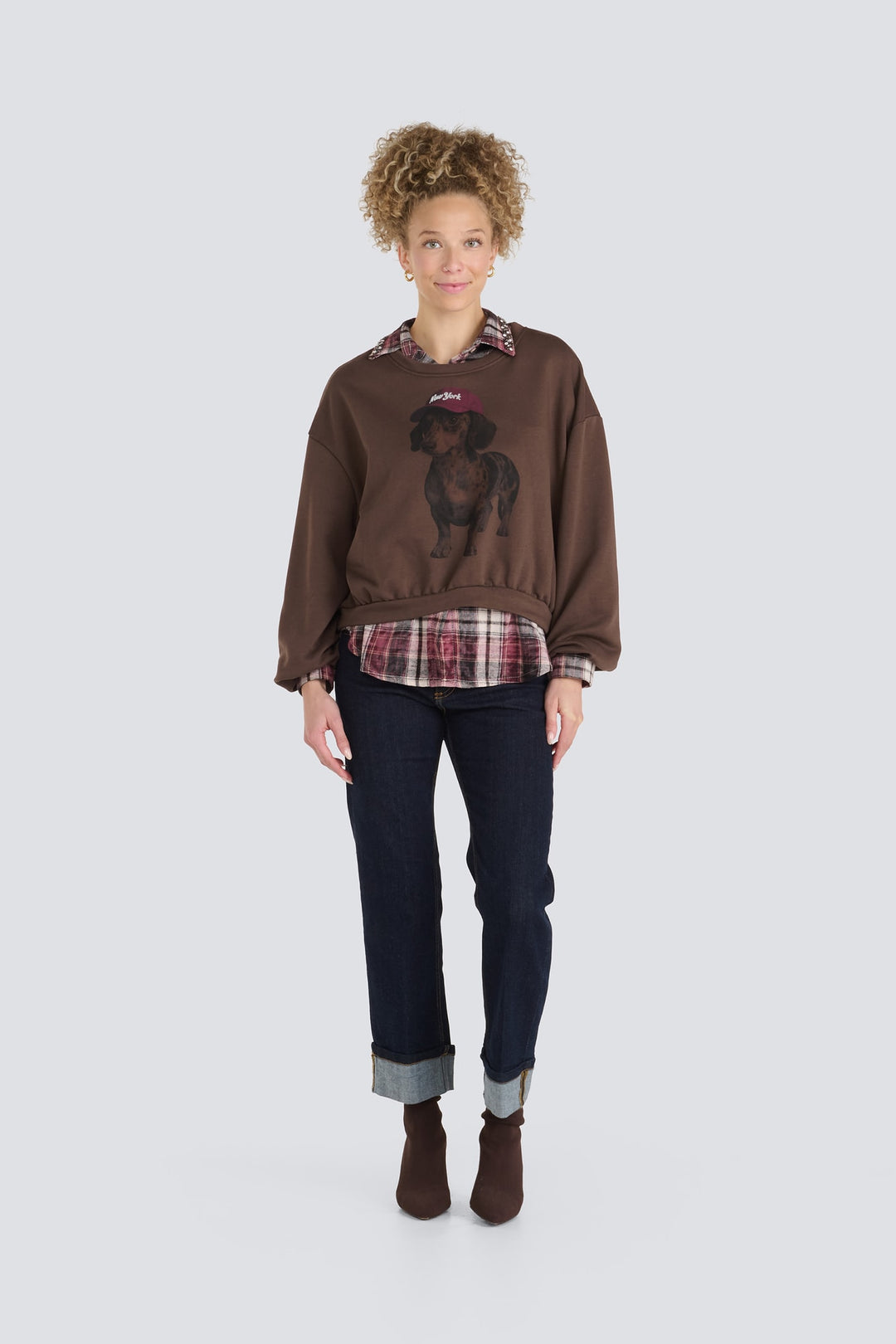 Brown sweater featuring a graphic of a dachshund wearing a red cap.