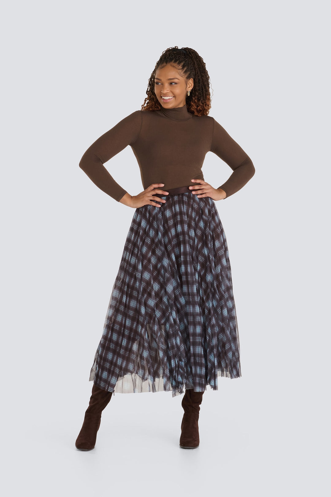 Brown long-sleeve turtleneck top paired with a blue and brown plaid pleated midi skirt.