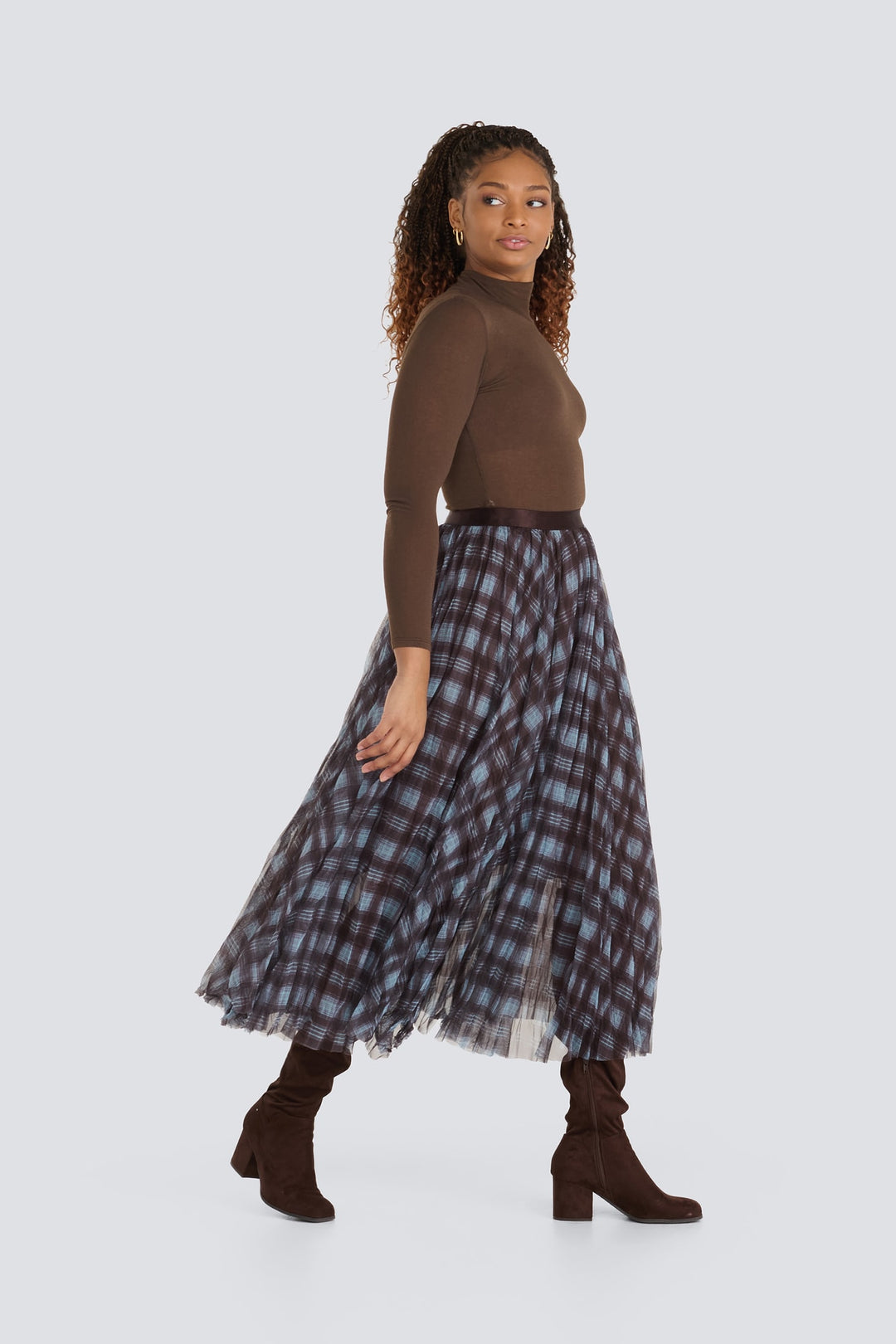 Brown turtleneck top paired with a blue and brown plaid pleated midi skirt.