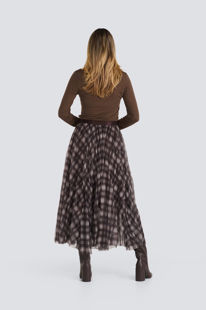 Brown long-sleeve top tucked into a pleated brown plaid midi skirt.