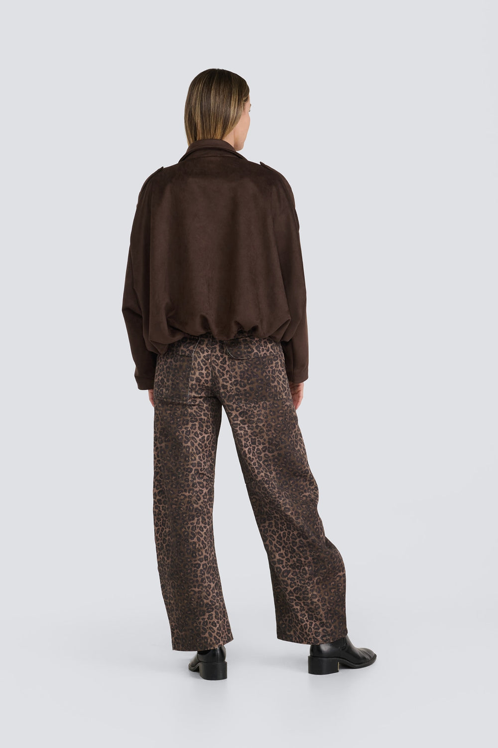 Dark brown suede jacket paired with leopard-print wide-leg pants.