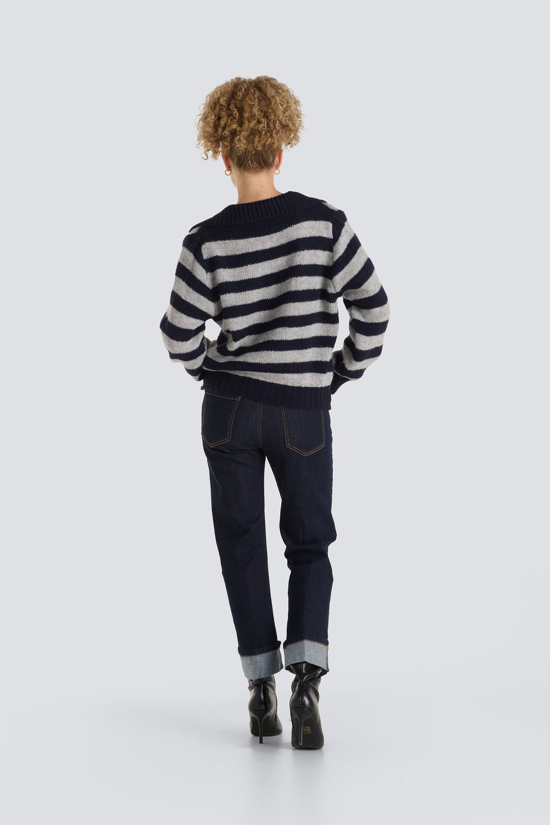 Navy and grey horizontal striped knit sweater paired with dark wash jeans.