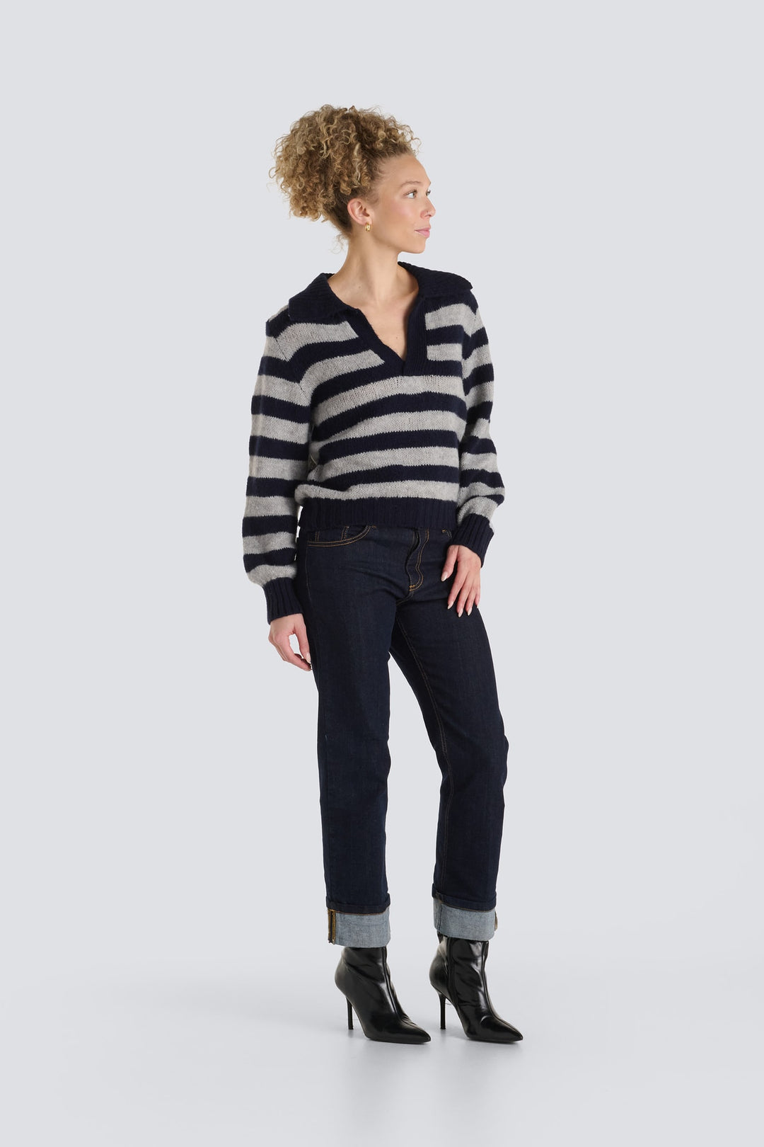 Grey and navy blue striped knit sweater with an open V-neck collar.