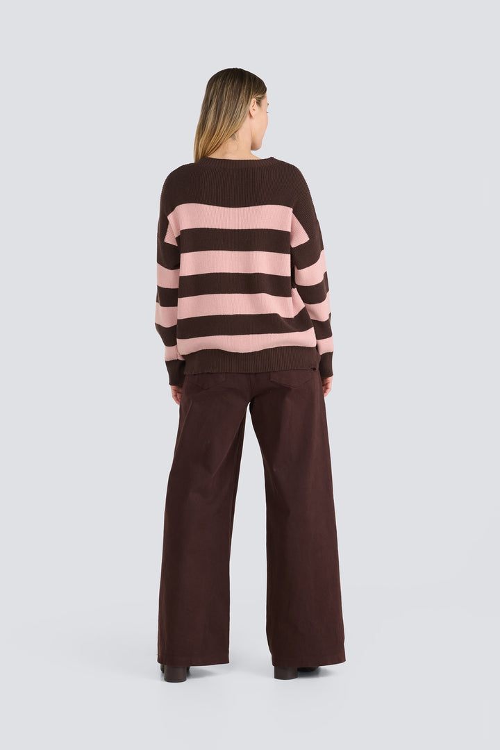 Brown and light pink striped knit sweater paired with dark brown wide-leg pants.