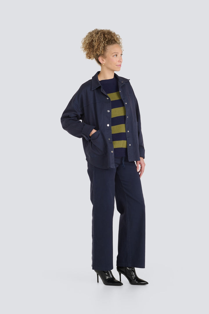 Dark navy snap-button jacket layered over a green and navy striped sweater.