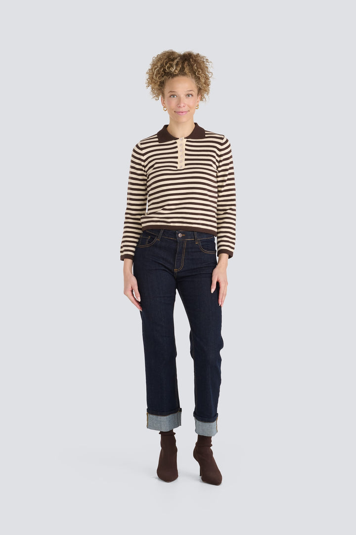 Brown and cream striped long-sleeve polo sweater paired with dark cuffed jeans.
