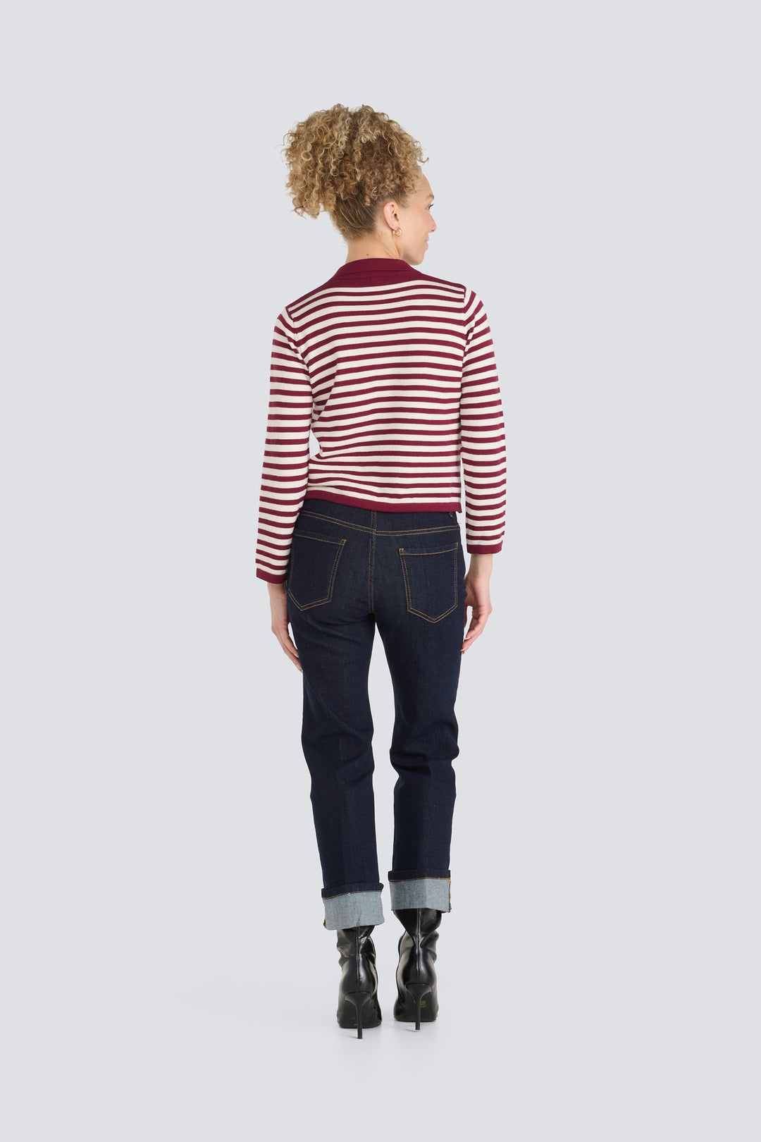 Burgundy and white striped long-sleeve sweater paired with dark blue cuffed jeans.