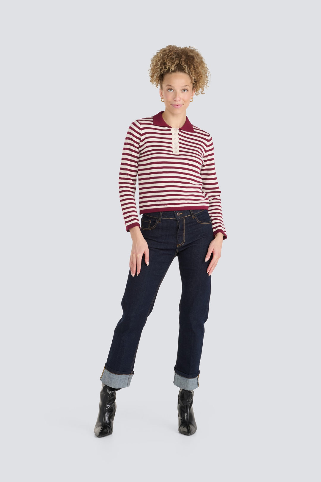 Burgundy and cream striped long-sleeve polo sweater paired with dark cuffed jeans.