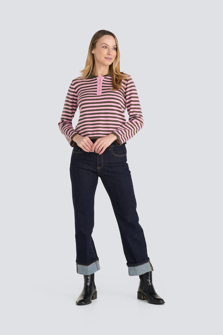 Pink and olive green striped long-sleeve polo shirt paired with dark cuffed jeans.